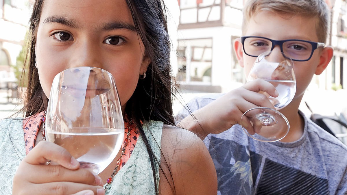 Junge und Mädchen trinken frisches Wasser